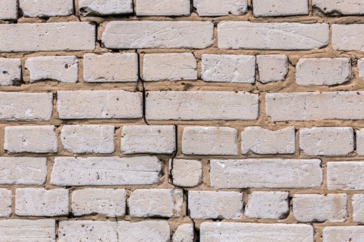 Deep cracked white silicate brick wall closeup texture and background. Horizontal shot.
