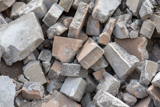 Pile of dismounted gray modern urban pavement bricks with selective focus. Result of russian government corruption in city infrastructure renovation.