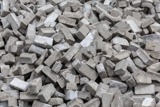 Pile of dismounted gray modern urban pavement bricks with selective focus. Result of russian government corruption in city infrastructure renovation.