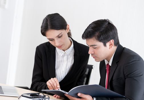 A manager and secretary working together in the office.