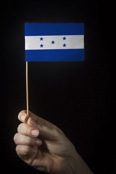 Hand with small flag of state of Honduras