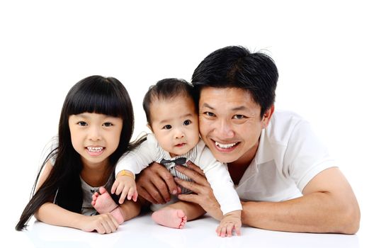 Asian father and his cute daughter and son lying down on the floor isolated on white background.