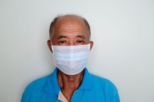 Portrait of an asian senior man, 60 years old wearing medical mask. A concept of the danger of coronavirus for the elderly.