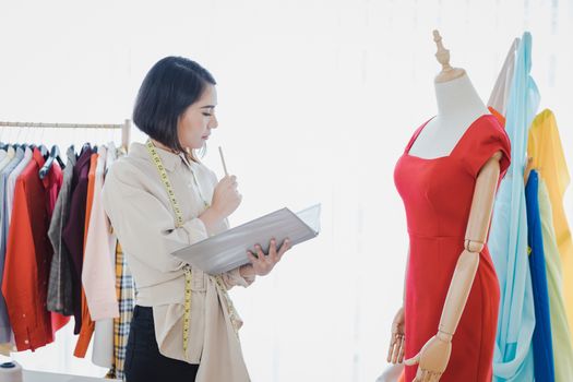 Professional fashion designers are checking new clothes that have been cut and delivered to customers.