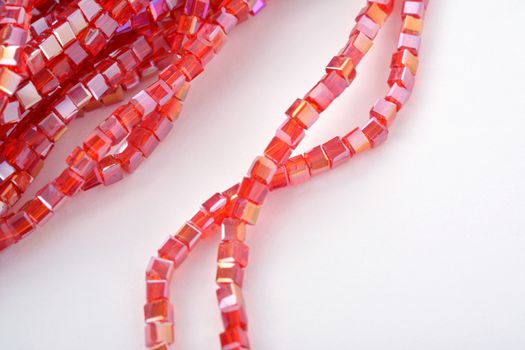 Beautiful Red scarlet, ruby Glass Sparkle Crystal Isoalted Beads on white background. Use for diy beaded jewelry. Space for text