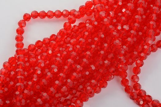 Beautiful Red scarlet, ruby Glass Sparkle Crystal Isoalted Beads on white background. Use for diy beaded jewelry. Space for text