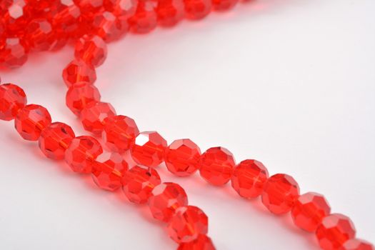 Beautiful Red scarlet, ruby Glass Sparkle Crystal Isoalted Beads on white background. Use for diy beaded jewelry. Space for text