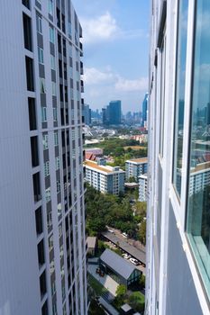 View from the high floor of the streets of Bangkok. Tall buildings and roofs of small houses. City landscape.