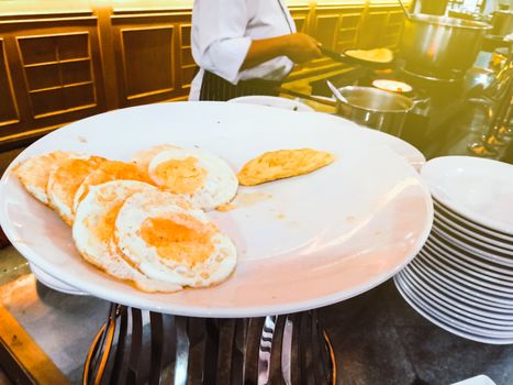 The cook is frying fried eggs and omelettes prepared for customers in the restaurant.
