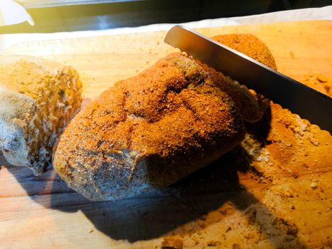 Whole grain bread on cutting board with knife