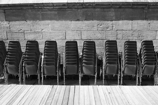 Rows of plastic chairs near a concert hall in black and white.  Cultural institutions are closed for quarantine