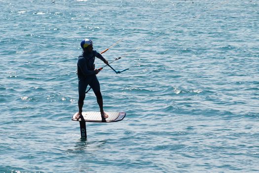 Varna, Bulgaria - July, 19, 2020: a man is kiting the sea on a sunny windy day