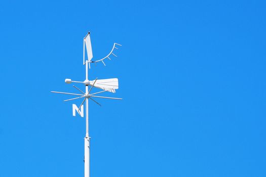 weather station weather vane close-up on a background of clear blue sky, copy space