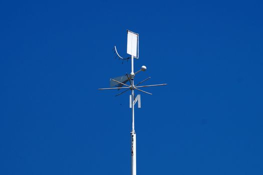 weather station weather vane close-up on a background of clear blue sky, copy space