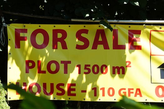 ad on the street for the sale of a plot with a house