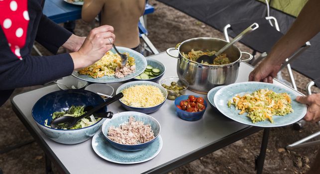 camping meal with lettuce and pasta with olives tomatoes and other