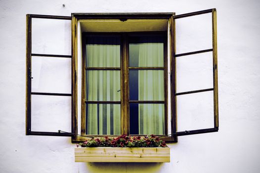 Typical window of a house in a small town in Austria. Home in the Austrian city of Hallstatt on a rainy day. Vintage style 