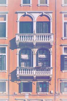 Italian culture on Venetian facades in faded color effect. Venice is rich and poor, well-groomed and abandoned, reflected in its windows.