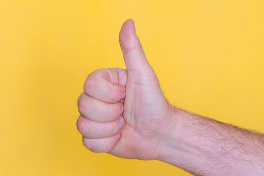 thumb up sign on yellow background