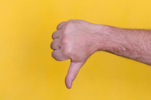 The thumb down sign on yellow background