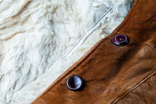 small brown thick seude jacket with white sheep fur lining closeup texture and background with selective focus and blur