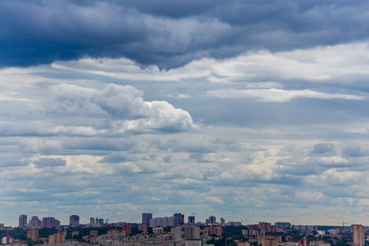 russian summer daylight cityscape with large cumulus clouds and tiny horizon line of the panel condominium houses.