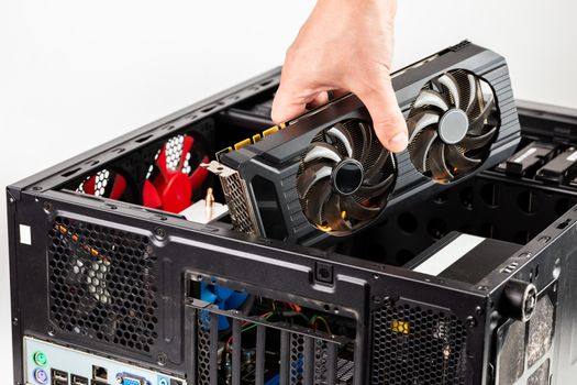 hand plugging a video card while maintenance personal computer hardware with selective focus closeup