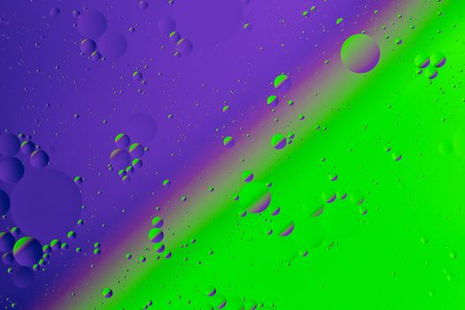 Oil on water flat colorful duotone macro abstract background photographic image. Violet-green diagonal split line.