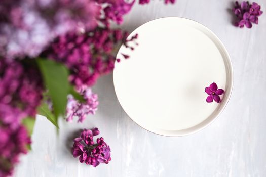 Five-pointed lilac flower among lilac flowers in a cup with water. Spa ritual. Lilac branch with a flower with 5 petals.