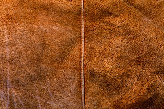small brown weathered seude jacket closeup texture with selective focus and blur