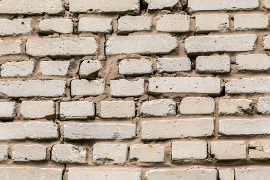 Deep cracked white silicate brick wall closeup texture and background. Horizontal shot.