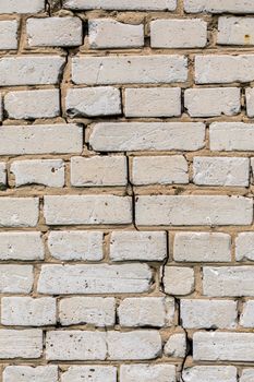 Deep cracked white silicate brick wall closeup texture and background. Vertical shot.