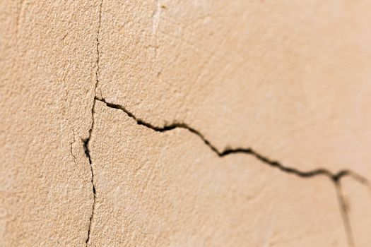 closeup background of cracked light porple plaster wall with selective focus and naturla blur.