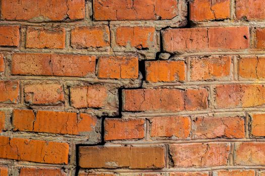 deep cracked orange brick wall closeup texture.