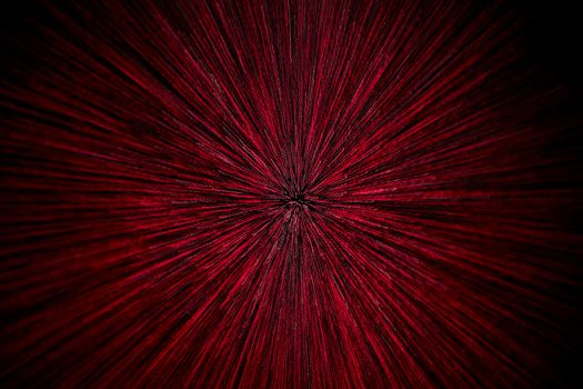 natural lens zoom explosion radial blurred red particles on black background with selective focus.
