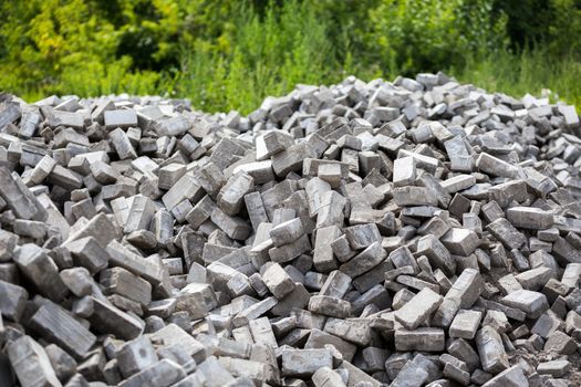 Pile of dismounted gray modern urban pavement bricks with selective focus. Result of russian government corruption in city infrastructure renovation.
