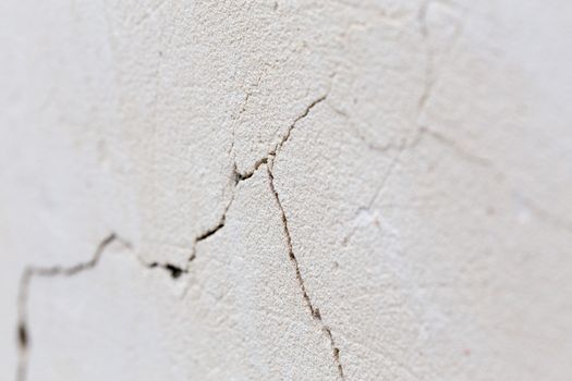 closeup background of cracked light porple plaster wall with selective focus and naturla blur.