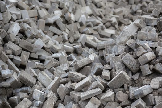 Pile of dismounted gray modern urban pavement bricks with selective focus. Result of russian government corruption in city infrastructure renovation.