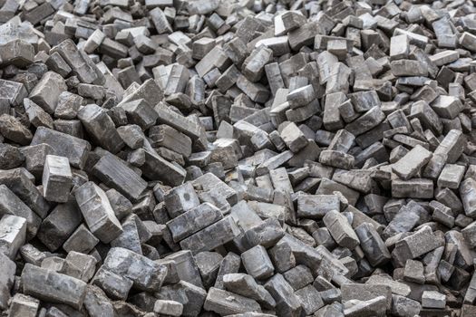 Pile of dismounted gray modern urban pavement bricks with selective focus. Result of russian government corruption in city infrastructure renovation.