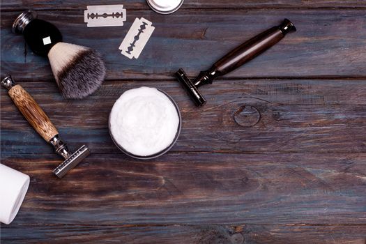 Razor, brush, perfume, blades, balsam, and shaving foam on a black background.