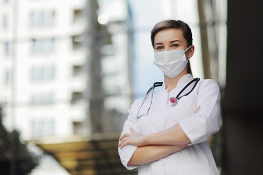 Confident female doctor or nurse wearing a face protective mask. Safety measures against the coronavirus. Prevention Covid-19 healthcare concept. Stethoscope over the neck. Woman, girl.