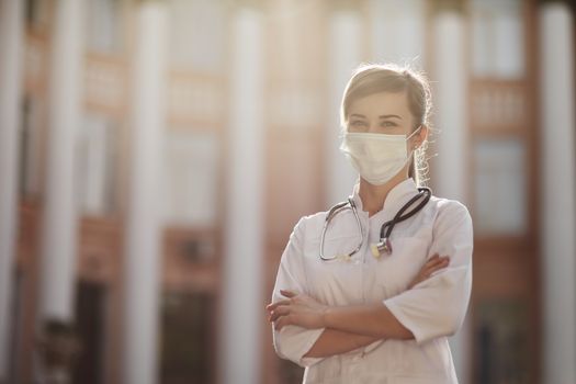 Confident female doctor or nurse wearing a face protective mask. Safety measures against the coronavirus. Prevention Covid-19 healthcare concept. Stethoscope over the neck. Woman, girl.
