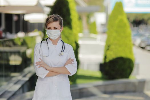 Confident female doctor or nurse wearing a face protective mask. Safety measures against the coronavirus. Prevention Covid-19 healthcare concept. Stethoscope over the neck. Woman, girl.