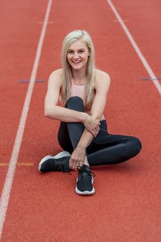 A beautiful young college athlete prepares herself for a track meet at a local university