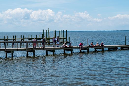 Duck, North Carolina, USA -- June 9, 2020.  Photo of people fishing and crabbing from a pier in Duck, NC.