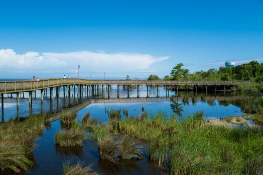 Duck, North Carolina, USA -- June 17, 2020.  A wide angle photo of the boardwalk that crosses over the water of Currituck Sound in Duck, NC.