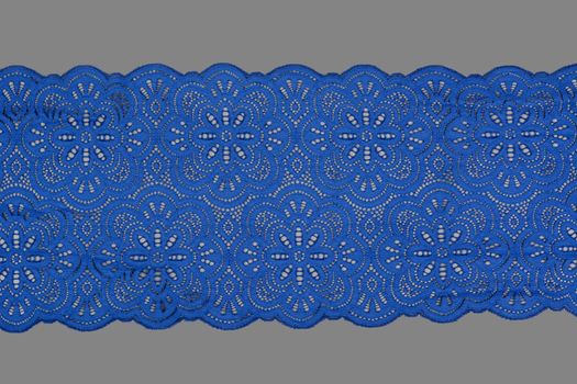 blue color straight strip of lace fabric on gray background. Elastic silk nylon braid border. use clothes linen decoration. repeating pattern and interweaving threads. texture for websites