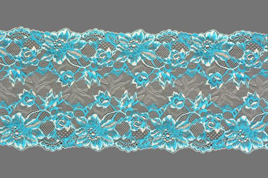 white blue color straight strip of lace fabric on gray background. Elastic silk nylon braid border. use clothes linen decoration. repeating pattern and interweaving threads. texture for websites