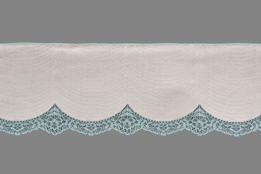beige blue color straight strip of lace fabric on gray background. Elastic silk nylon braid border. use clothes linen decoration. repeating pattern and interweaving threads. texture for websites