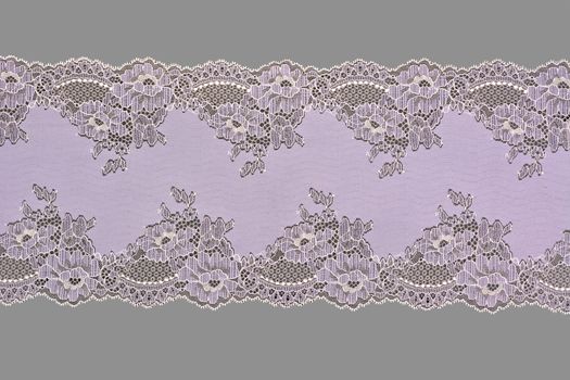 lilac beige color straight strip of lace fabric on gray background. Elastic silk nylon braid border. use clothes linen decoration. repeating pattern and interweaving threads. texture for websites